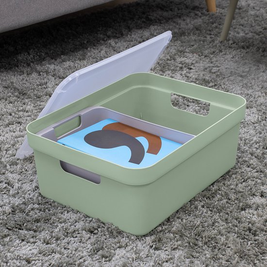 Lichtgroene opbergbox met een losse, doorschijnende deksel, gevuld met een blauw boek met een zwarte vorm.