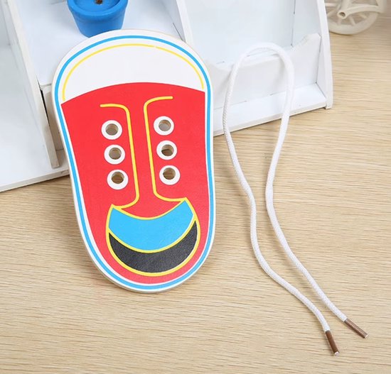 Houten veteroefenschoentje in rood met blauwe en zwarte accenten en losse witte veters.