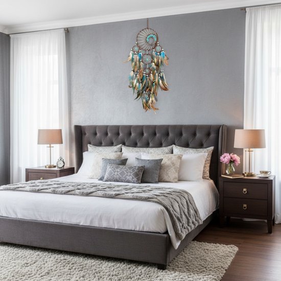 Dromenvanger met blauwe en bruine veren hangend boven een bed met gestoffeerd hoofdbord.