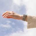 Damespols in de lucht met een smartwatch en Starlight Milanese bandje.