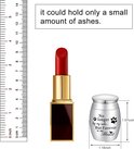 Afmetingen van de zilverkleurige mini-urn (hoogte 1.57 inch, breedte 1.18 inch) vergeleken met een rode lipstick en een meetlat.