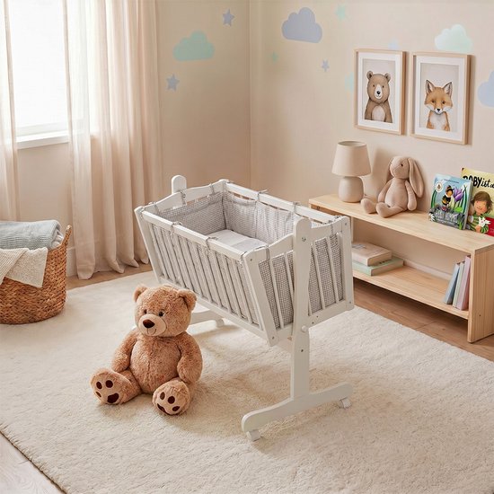Witte wieg met grijze ruitjes bekleding in een kinderkamer met een teddybeer en een stoffen mand.