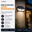 AXIMO solar buitenlamp aan een muur gemonteerd, brandend in de regen. De lamp is duurzaam, hitte- & vorstbestendig, weerbestendig en IP65 waterdicht.
