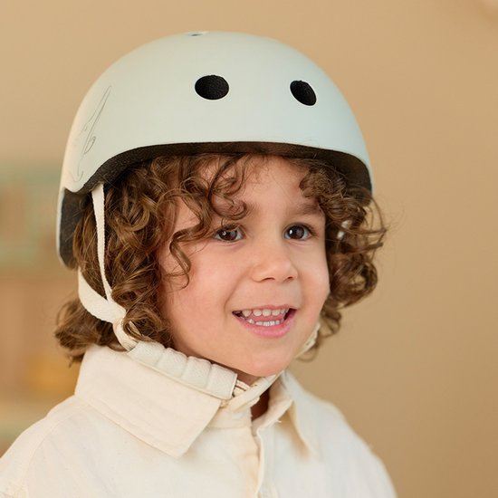 Lichtgroene kinderhelm met krokodillenprint, gedragen door een jongen.
