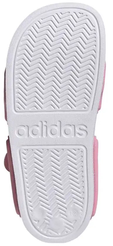 Onderkant van roze Adilette sandalen voor kinderen met witte zool en Adidas logo.