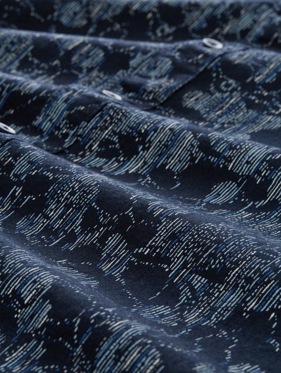 Donkerblauw katoenen overhemd met een wit en lichtblauw lineair patroon, close-up van de stof.