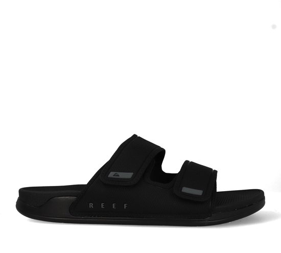 Zijkant van een zwarte Reef slipper met verstelbare bandjes.