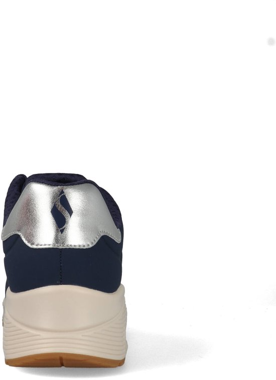 Achterkant van een donkerblauwe Skechers sneaker met zilveren detail op de hiel en beige zool.