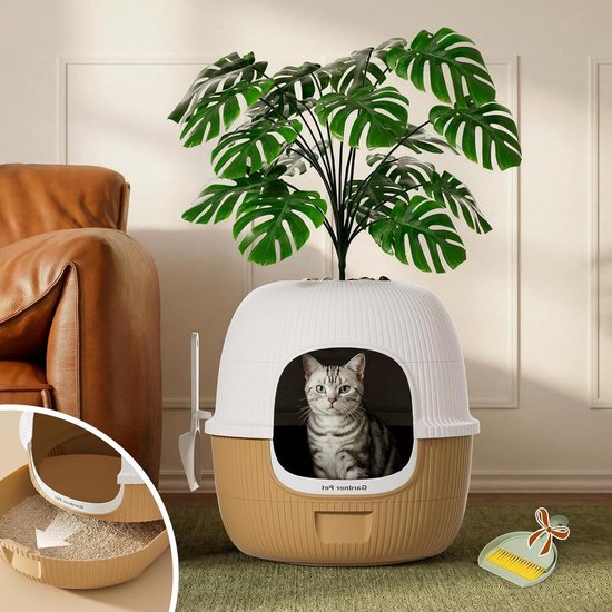 Grijze tabby kat in een witte en bruine kattenbak, met een decoratieve plant bovenop en een lade met kattenbakvulling.