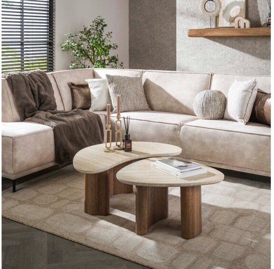 Woonkamer met beige hoekbank en twee organische salontafels met travertin blad.