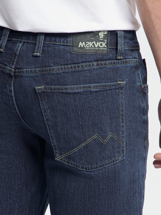 Detail van de achterzak van een donkerblauwe jeans met gele stiksels en M2KVCK label.