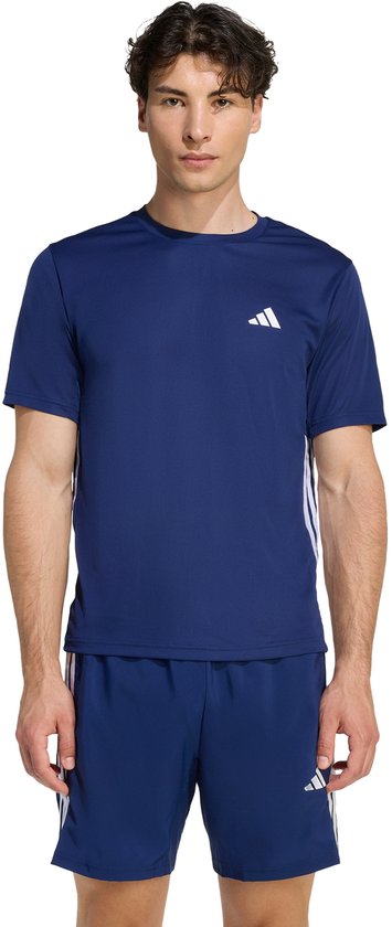 Man in donkerblauw sport T-shirt en korte broek met witte Adidas strepen en logo's.