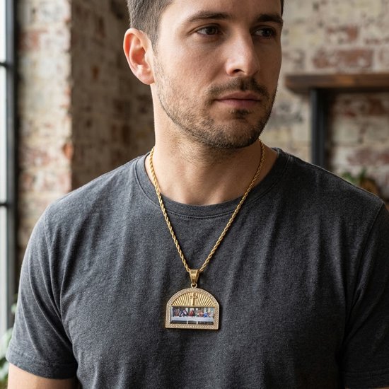 Man draagt gouden ketting met hanger van het Laatste Avondmaal, versierd met strass.