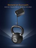 Grijze powerbank hangt aan een dunne kabel boven een 15kg kettlebell. "Bestand en duurzaam".