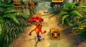 Crash Bandicoot rent op een zanderig pad in de jungle, met kratten en een rode krab. Veel groen en palmbomen.