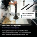 Een vrouw gebruikt een stoomreiniger met borstelopzetstuk op een vuile ovenplaat. Inclusief verlengstuk.