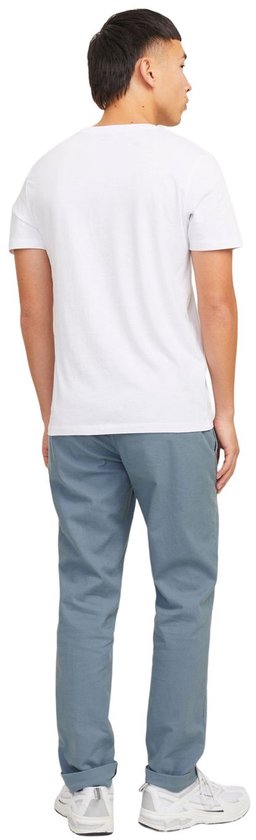 Jonge man, volledig van achteren gezien, in een witte T-shirt en een grijze chino broek.