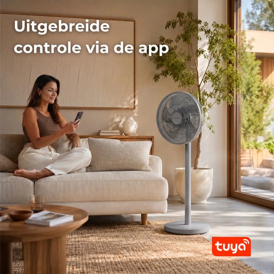 Vrouw op bank met smartphone bedient grijze staande ventilator. Tekst 'Uitgebreide controle via de app'.