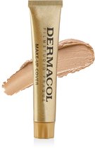 Een gouden tube Dermacol Make-Up Cover met een veeg beige foundation ernaast.
