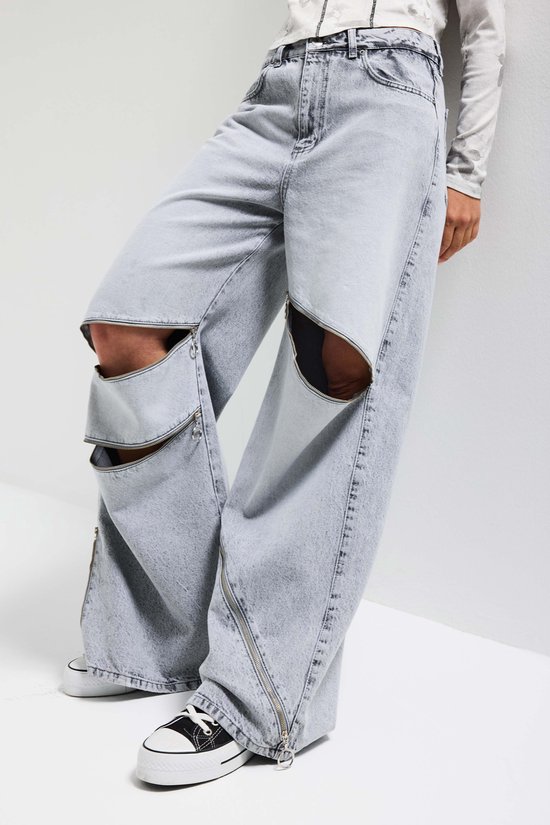 Lichtgrijze baggy jeans met ritsen en opengewerkte knieën.