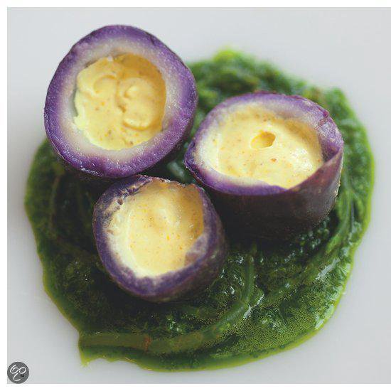 Paarse aardappelschijfjes gevuld met room, geserveerd op groene puree.