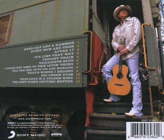 Alan Jackson staat op de trap van een treinwagon met een gitaar. De lijst met nummers staat op de wagon.