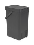 Poubelle Brabantia gris foncé avec couvercle et anse, avec une découpe en bas.
