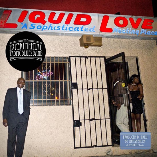 Een man in een pak buiten een gebouw met een bord "LIQUID LOVE "A Sophisticated Meeting Place".
