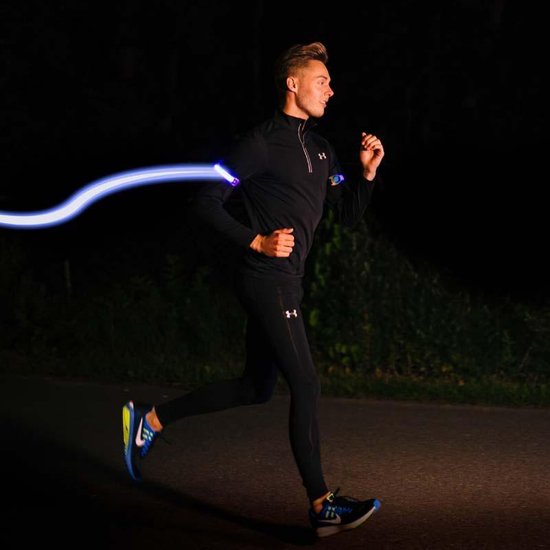 Man in zwart trainingspak en blauwe hardloopschoenen met een blauw oplichtende armband om zijn arm.