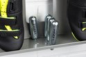 Close-up van CO2-patronen en zwarte racefietsschoenen met limegroene accenten op een zilverkleurig Stasdock-rek.