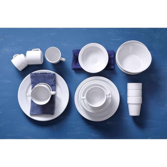 Witte mokken, koppen, schotels en borden, gerangschikt op een blauwe houten tafel.