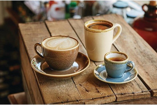 Drie mokken met koffie op een houten tafel. Twee mokken met cappuccino, één espresso.