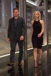 Chris Pratt in pak en Jennifer Lawrence in zwarte jurk lopen in een gang.