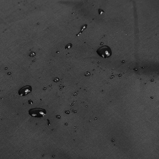 Close-up van het zwarte, waterdichte materiaal van de scootmobielhoes met waterdruppels erop.
