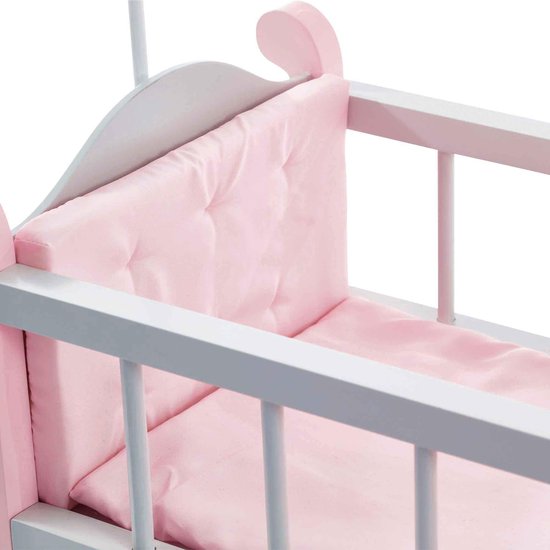 Gedetailleerde foto van de roze kussens en het grijze bedframe van een poppenbedje.
