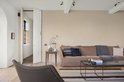 Woonkamer met grote bruine bank, salontafel, open haard en een stoel.