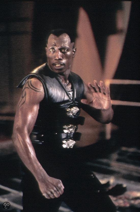 Wesley Snipes met tatoeage op arm, draagt zwart vest met metalen gespen.