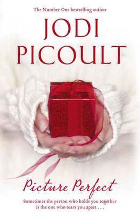 Boekcover van 'Picture Perfect' door Jodi Picoult, met handen die een rood geschenk vasthouden.