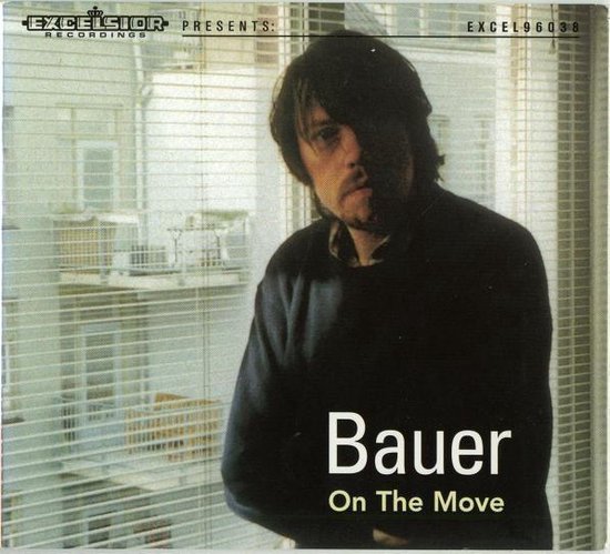 Albumhoes: Bauer, On The Move. Een man met donker haar staat voor een raam met jaloezieën.