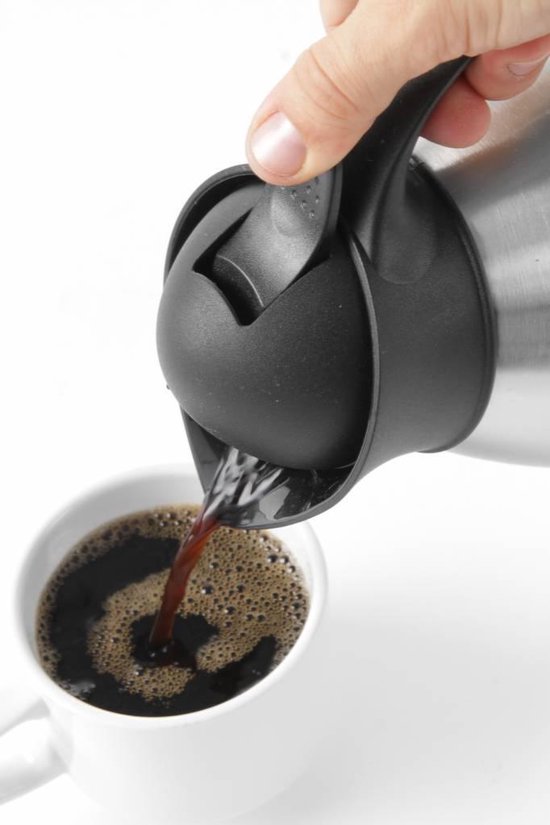 Een hand schenkt koffie uit een roestvrijstalen thermoskan in een witte mok.