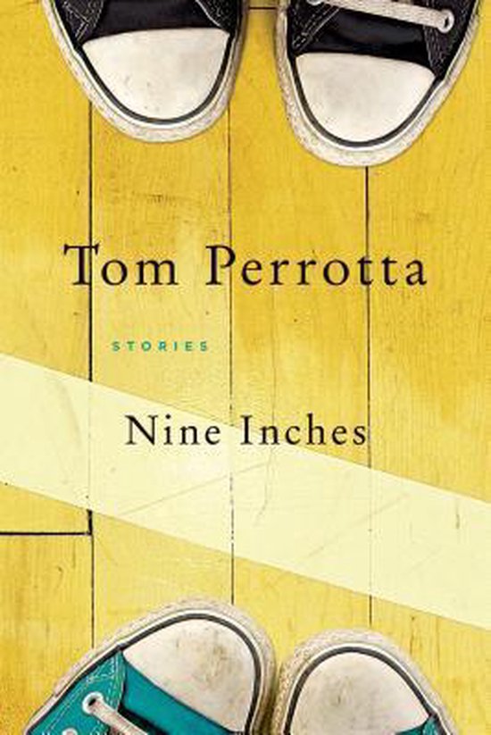 Boek "Nine Inches" van Tom Perrotta, met sneakers en een gele baan op een houten vloer.