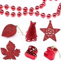 Collage van rode kerstdecoraties: kerstsnoer, bal met glitters, klokje, ster, blad, laarsjes.