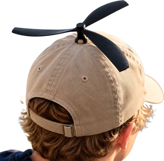 Achterkant van een beige pet met een zwarte propeller bovenop, gedragen door een persoon met bruin haar.