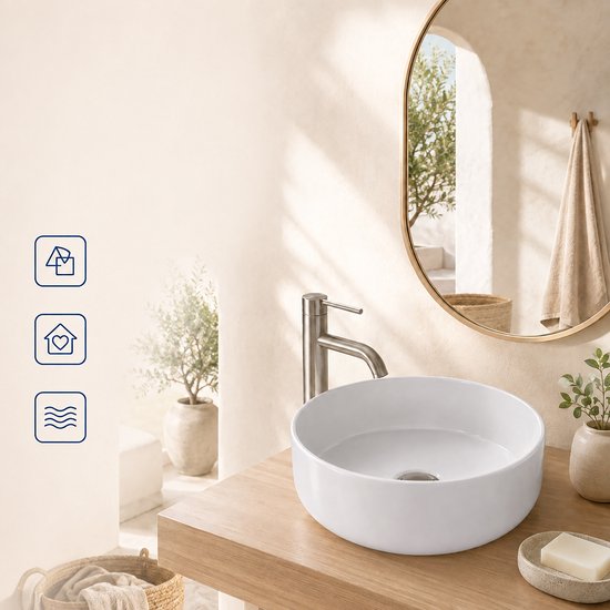 Witte opbouwwaskom in een modern badkamerinterieur met een ronde spiegel aan de muur.