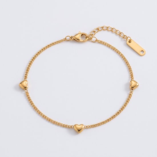 Goudkleurige armband met drie hartjes en verstelbare sluiting op een witte ondergrond.