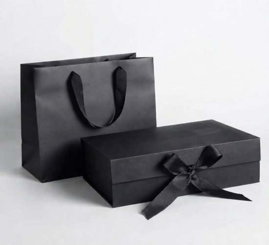Zwarte geschenkdoos met lintstrik naast een bijpassende zwarte papieren tas.