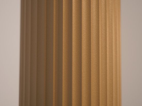 Detailopname van een zandkleurige cilinder met verticale ribbelstructuur en een korrelige afwerking.