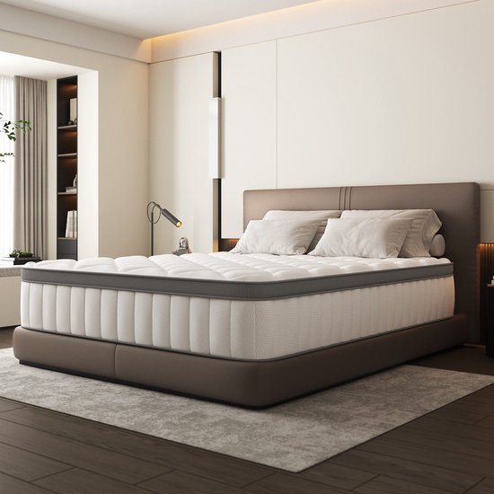 Luxe slaapkamerinterieur met een wit pocketveermatras op een bruin gestoffeerd bedframe.