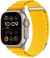 Apple Watch met felgele Alpine Loop nylon band en verstelbare metalen C-haak, scherm toont klok en data.