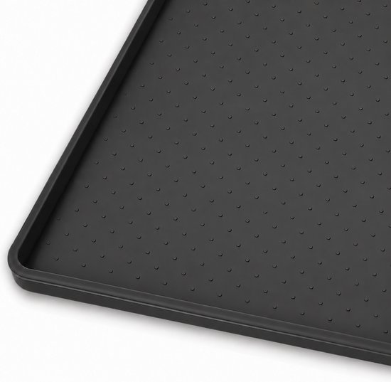 Close-up van zwarte siliconen voermat met antislip noppenpatroon en een opstaande rand.